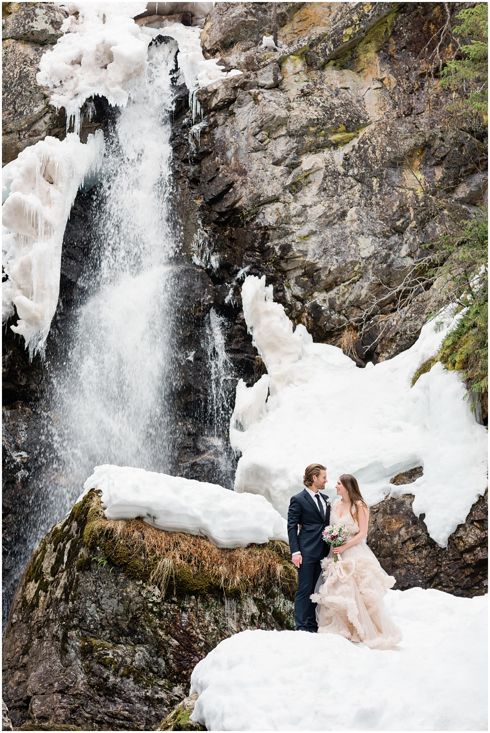 Bride and groom by waterfall
